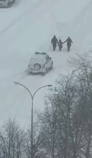 Полицейский помогает гражданам в непогоду